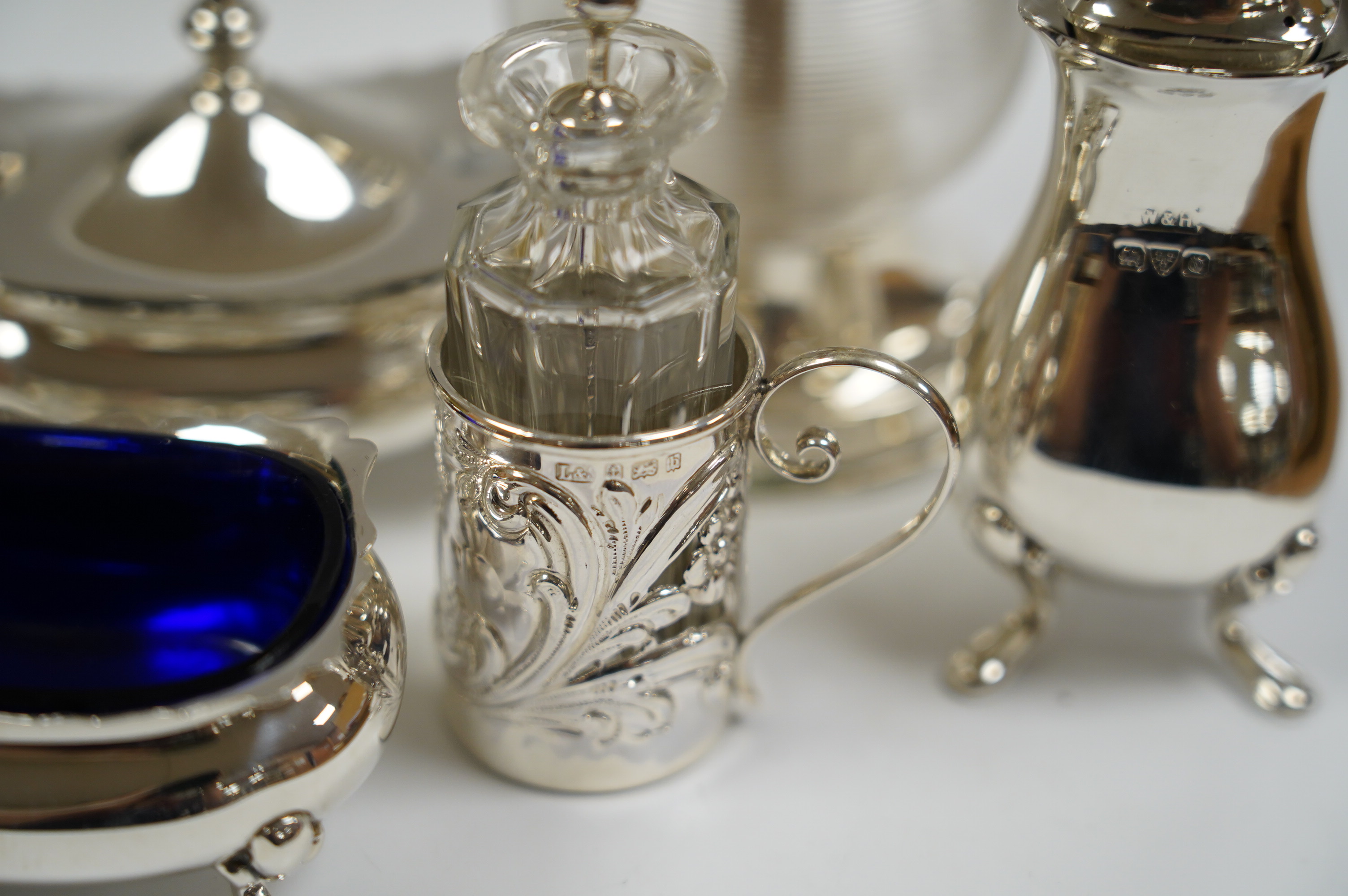 Six assorted silver condiments including a mounted ribbed glass pepper grinder and an Edwardian mounted glass cayenne pepper condiment, Condition - fair to good